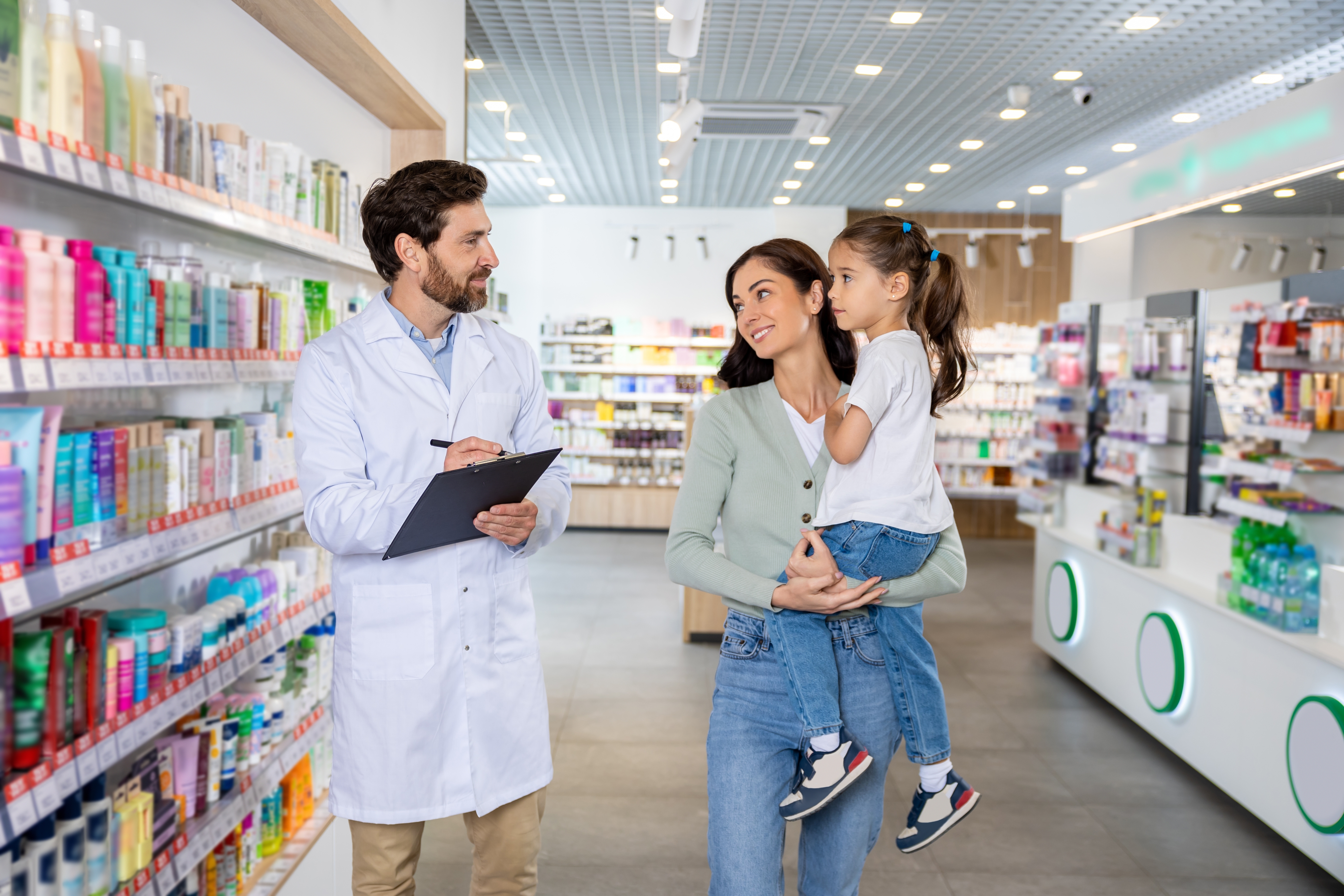 Mother and child talking to a pharmacist in a pharmacy