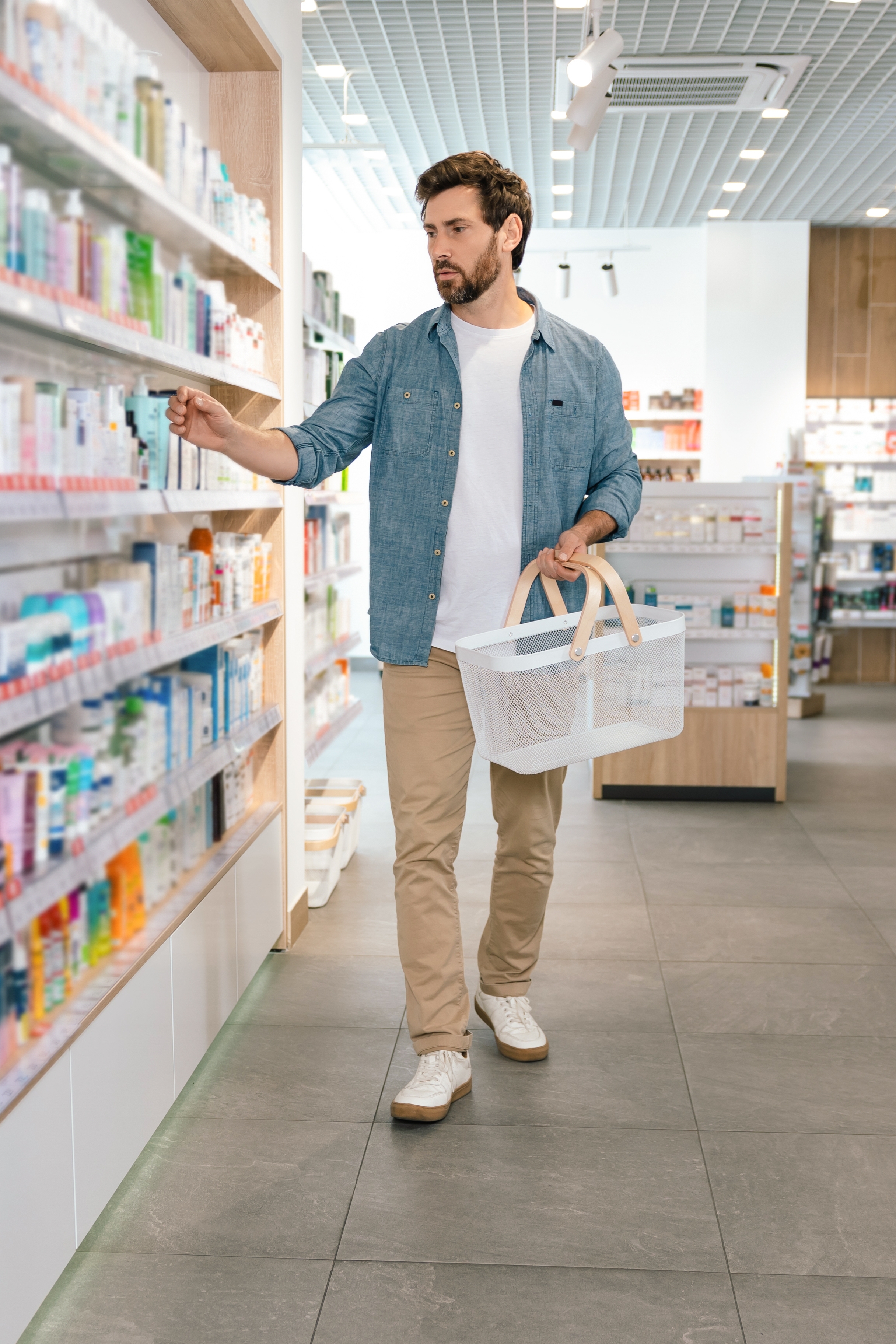Man choosing health supplements in a pharmacy